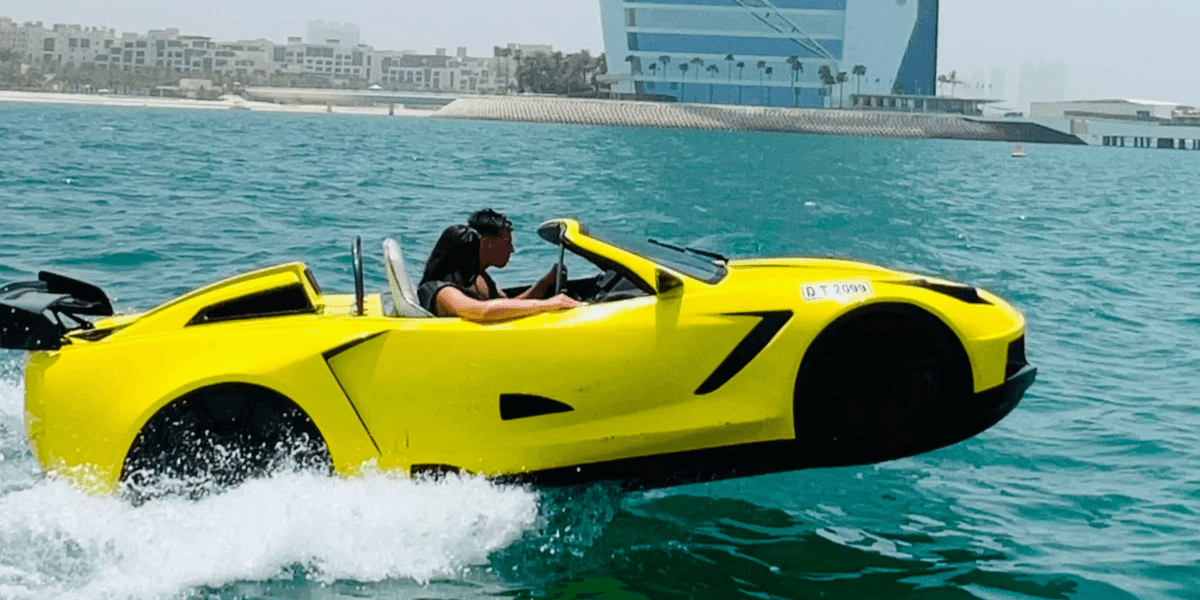Yellow car-shaped boat speeding across blue water with the Burj Al Arab in the background.